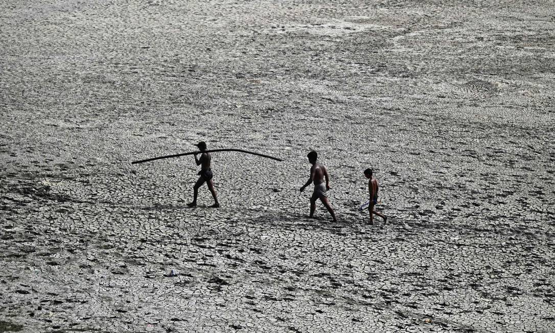 Pessoas caminham em leito seco do rio Yamuna em Nova Délhi Foto: SAJJAD HUSSAIN / AFP
