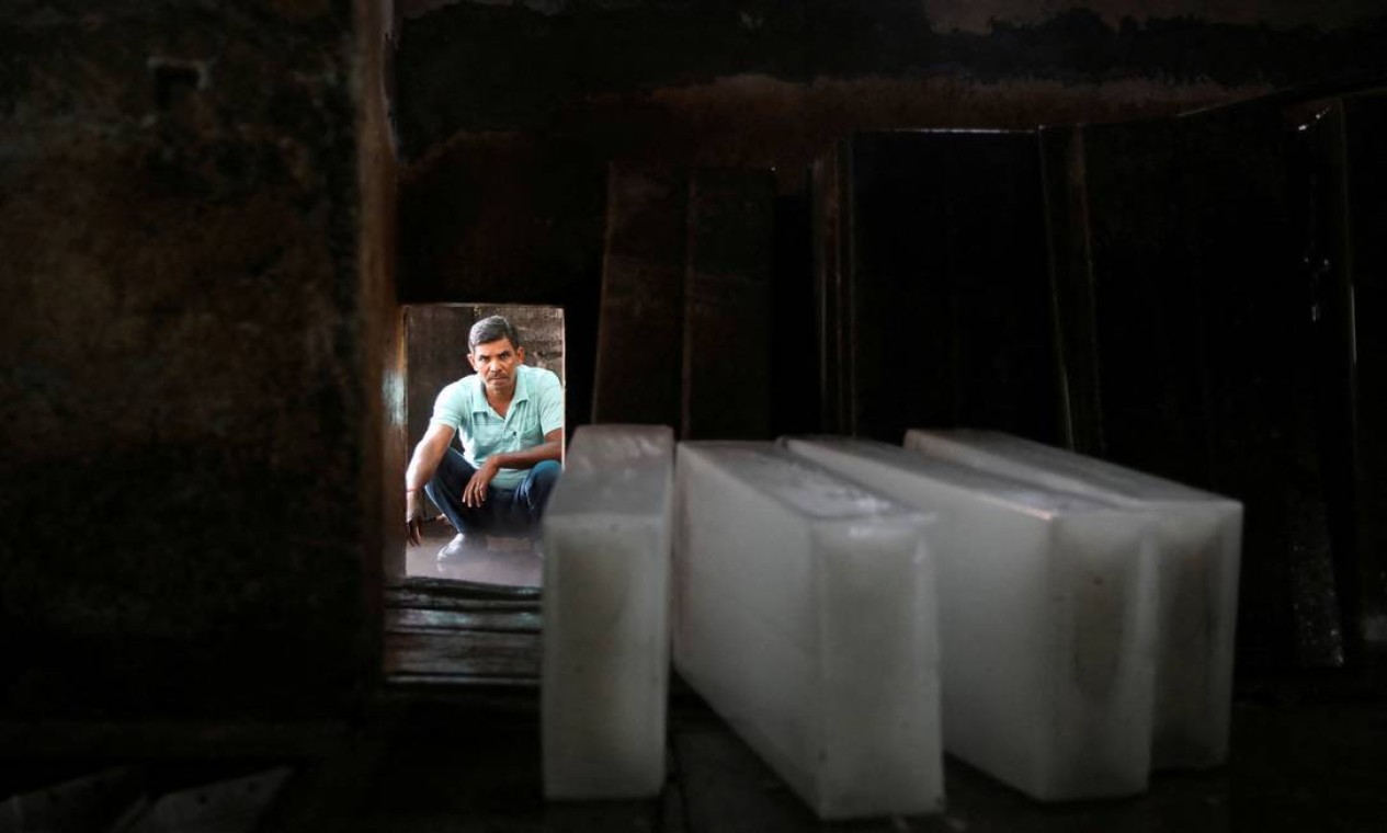 Homem espera para carregar blocos de gelo em um caminhão, em uma fábrica de gelo em Nova Délhi. Onda de calor atinge também áreas do Paquistão, afetando mais de 1 bilhão de pessoas ao todo Foto: ANUSHREE FADNAVIS / REUTERS