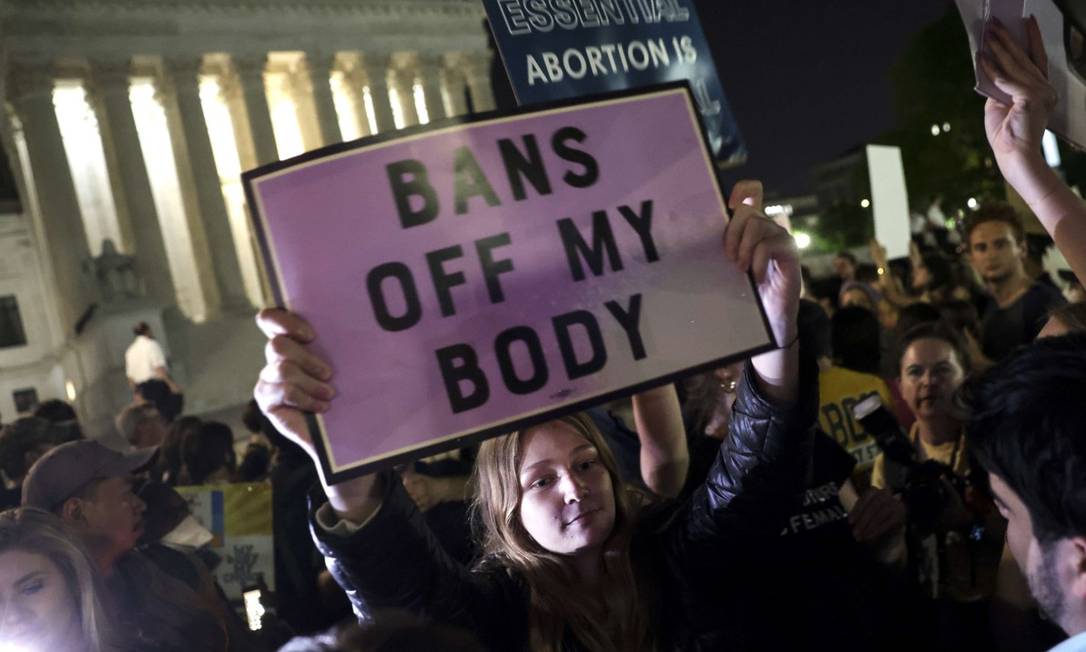 Manifestante do lado de fora da Suprema Corte dos EUA após o rascunho da decisão vazar: 'tire suas proibições de meu corpo', diz o cartaz Foto: Kevin Dietsch / AFP
