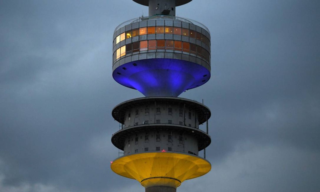 A torre de televisão de Munique, na Alemanha, é iluminada com as cores da bandeira ucraniana Foto: CHRISTOF STACHE / AFP