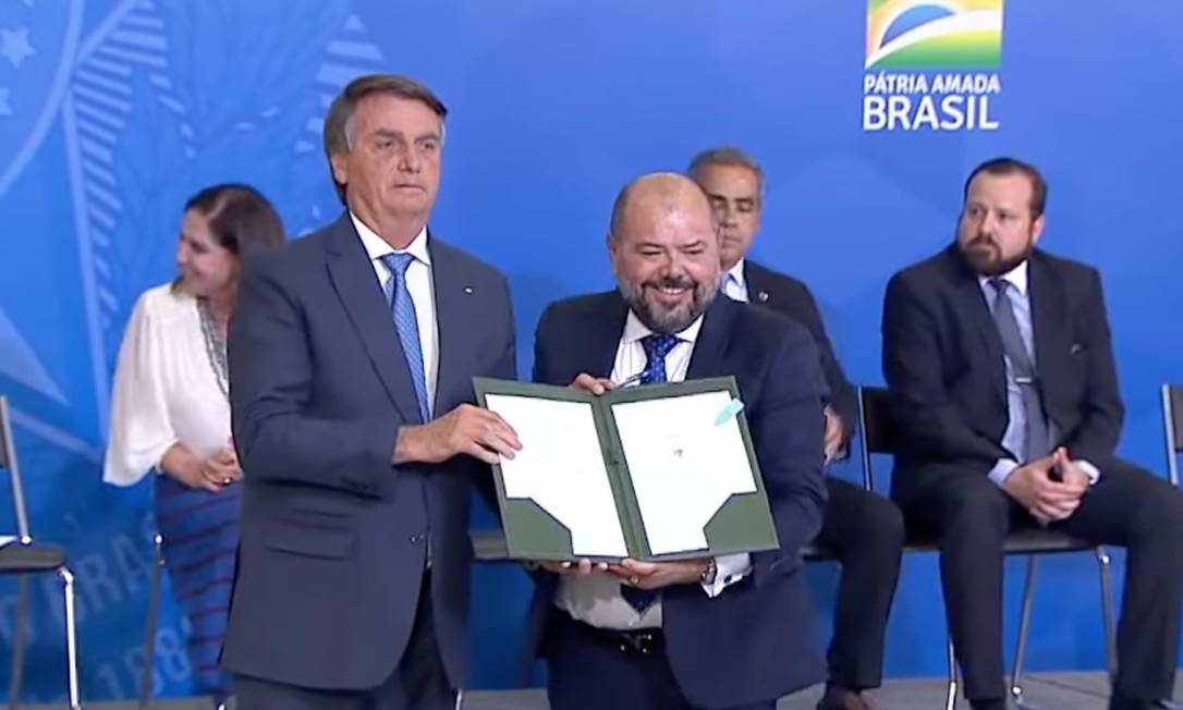 O presidente Jair Bolsonaro e o ministro do Trabalho José Carlos Oliveira durante cerimônia de assinatura do pacote trabalhista Foto: Reprodução