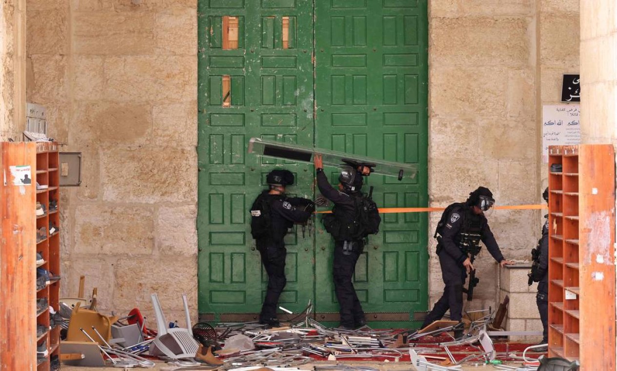 Polícia israelense protege a porta da mesquita de al-Aqsa, na Cidade Velha de Jerusalém, durante confronto provocado pela visita de um grupo de judeus ao complexo. O lugar é o terceiro mais sagrado do Islã e o mais importante do judaísmo, conhecido pelos judeus como o Monte do Templo Foto: AHMAD GHARABLI / AFP