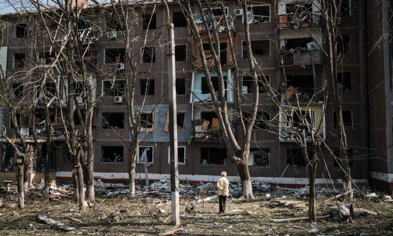 Idoso caminha em frente a um edifício bombardeado pelas forças militares russa em Kramatorsk, leste da Ucrânia Foto: YASUYOSHI CHIBA / AFP