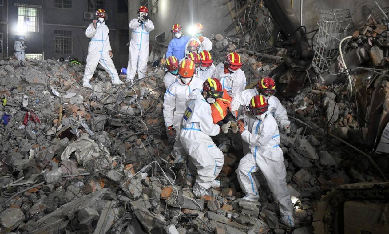 Equipes de resgate retiram um sobrevivente de um prédio de seis andares que desabou na província de Hunan, centro da China Foto: - / AFP