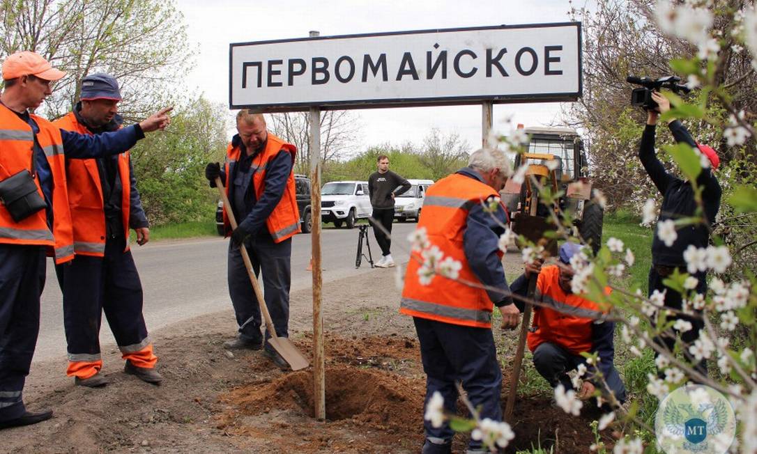 Foto divulgada pelo Ministério dos Transportes da República Popular de Donetsk em 5 de maio de 2022 mostra funcionários municipais trocando sinais de trânsito ucranianos para russos perto da cidade de Mariupol Foto: - / AFP