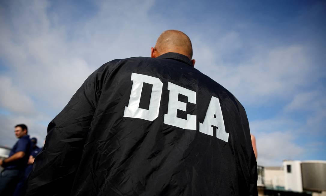 Um agente da Agência de Repressão às Drogas (DEA/EUA) vigia mais de 26.000 libras de cocaína, apreendidas em várias interdições antes de serem descarregadas na Flórida, em 2021 Foto: MARCO BELLO / REUTERS