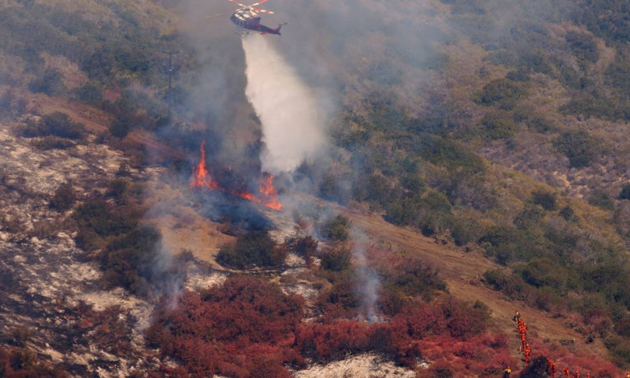 Helicóptero joga água sobre chamas na Califórnia Foto: MIKE BLAKE / REUTERS