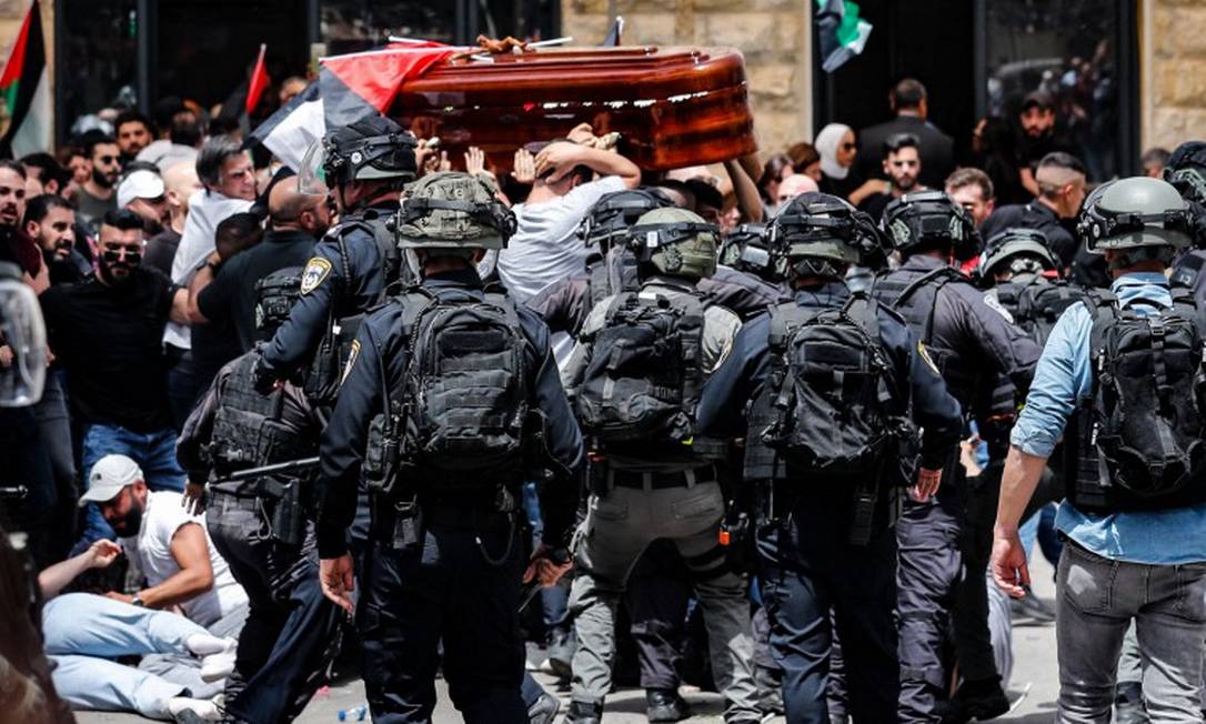 Forças de segurança de Israel impedem que pessoas carreguem o caixão com o corpo da jornalista da al-Jazeera Shireen Abu Akle durante uma procisão funerária para uma igreja, em Jerusalém Foto: AHMAD GHARABLI / AFP