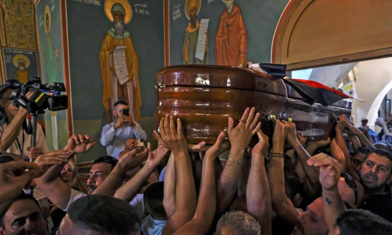 Palestinos carregam o caixão da jornalista assassinada da Al-Jazeera, Shireen Abu Aklel, dentro de uma igreja, antes de seu enterro em Jerusalém Foto: RONALDO SCHEMIDT / AFP