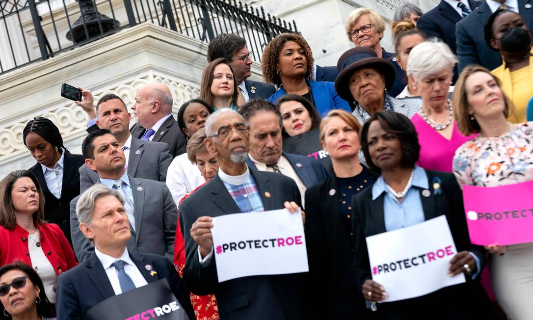 Em frente ao Capitólio, em Washington, parlamentares e ativistas exibem cartazes em favor da decisão que permite o aborto nos EUA Foto: STEFANI REYNOLDS / AFP