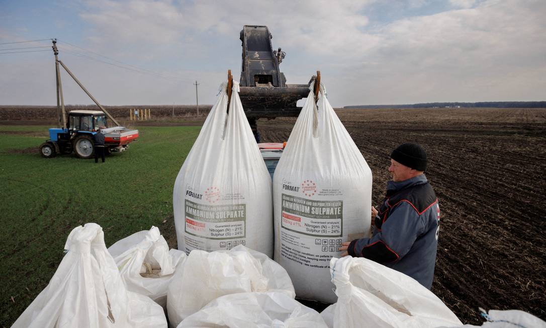 Fazendeiro descarrega caminhão com fertilizantes que serão usados em plantação de trigo, perto do vilarejo de Yakovlivka, nos arredores de Kharkiv Foto: THOMAS PETER / REUTERS