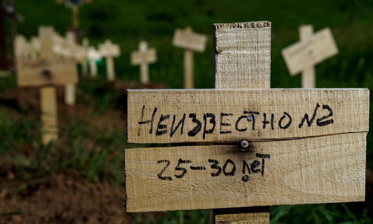 Guerra na Ucrânia. Em lápide improvisada e recém-colocada no cemitério de Mariupol se lê a "Desconhecido" Foto: STRINGER / AFP