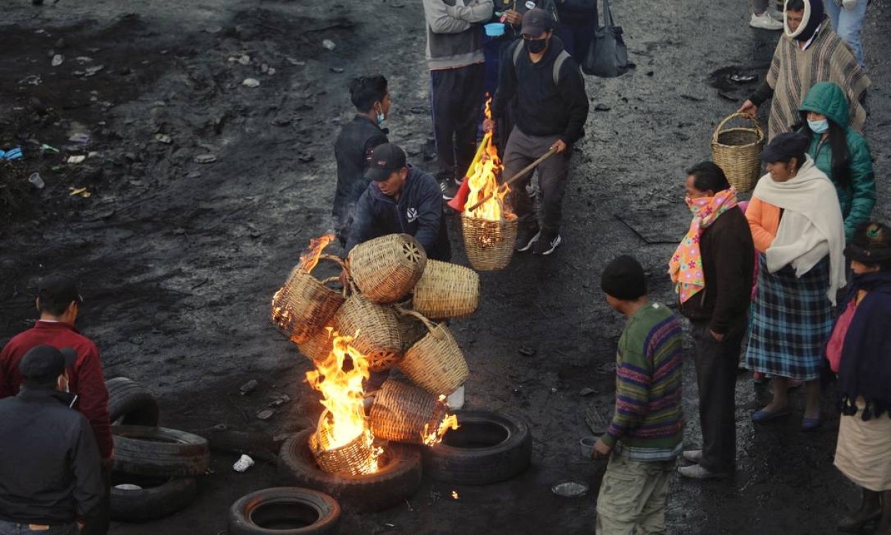 Indígenas e camponeses queimam pneus e cestos de vime em um bloqueio no bairro Cutuglagua, sul de Quito. Povos originários começaram há semanas uma jornada contra a alta do preço dos combustíveis no Equador Foto: CRISTINA VEGA RHOR / AFP