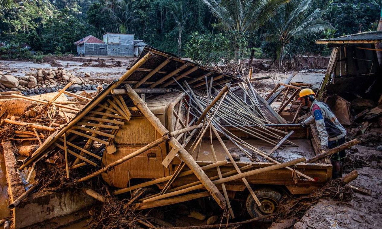 Equipe de resgate procura pessoas nos escombros de casas danificadas após uma inundação provocada por fortes chuvas atingir áreas residenciais na vila de Purasari, em Bogor, Indonésia Foto: ADITYA AJI / AFP