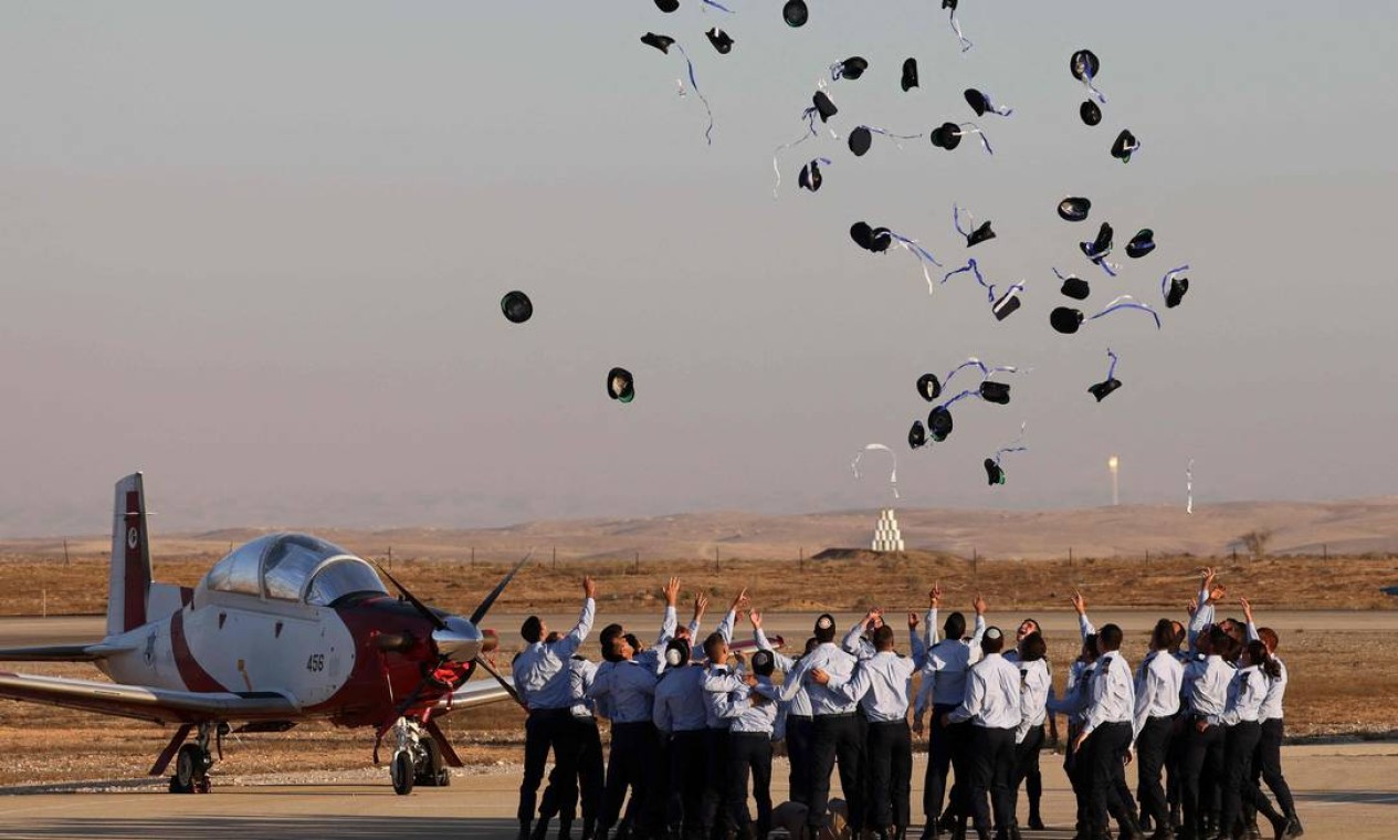 Pilotos da Força Aérea de Israel jogam seus chapéus para o ar durante a cerimônia de formatura na base de Hatzerim, no deserto de Negev, perto da cidade de Beer Sheva Foto: MENAHEM KAHANA / AFP