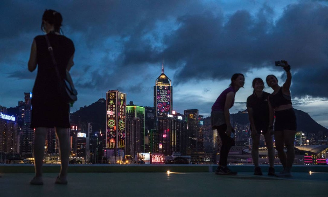 Em Hong Kong pessoas visitam um píer público próximo ao Victoria Harbour antes do 25º aniversário da transferência da cidade da Grã-Bretanha para a China Foto: DALE DE LA REY / AFP