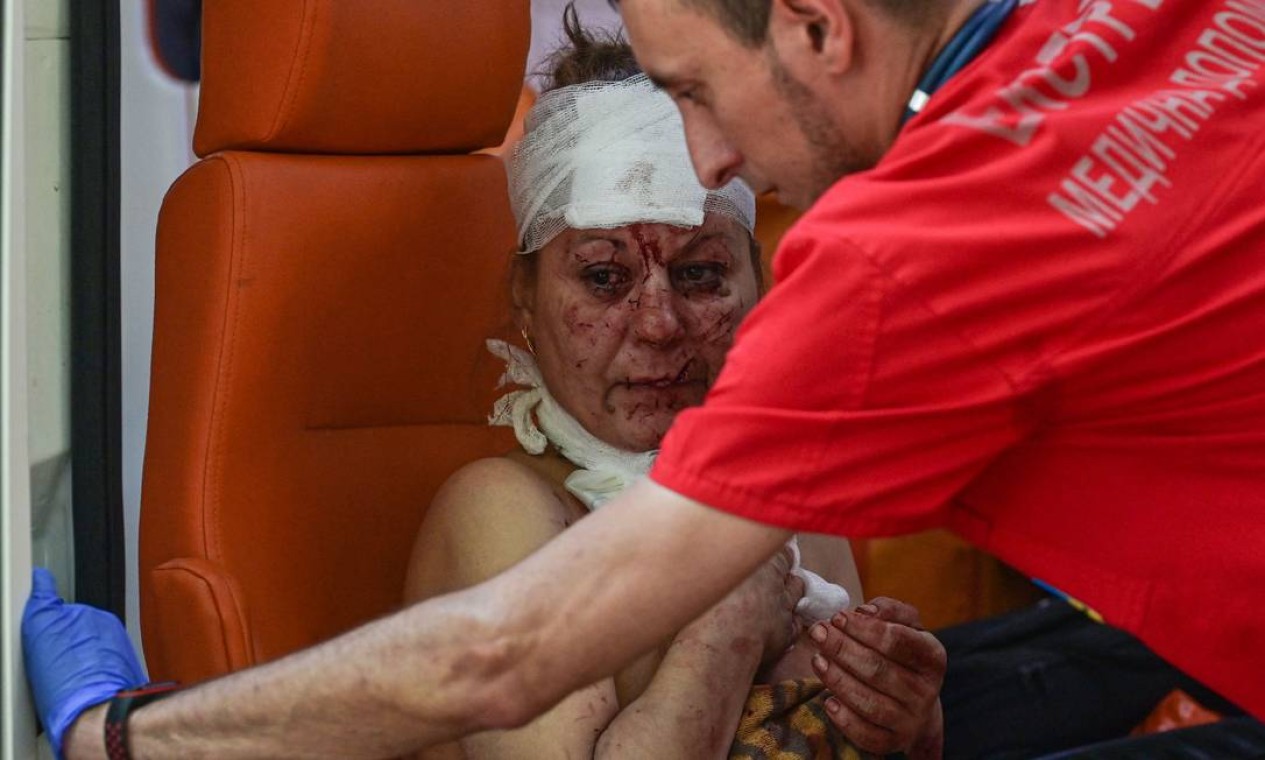 Mulher ferida é socorrida por enfermeira após um ataque aéreo no pátio do hotel Industria e residências civis no centro de Kramatorsk, Ucrânia Foto: MIGUEL MEDINA / AFP