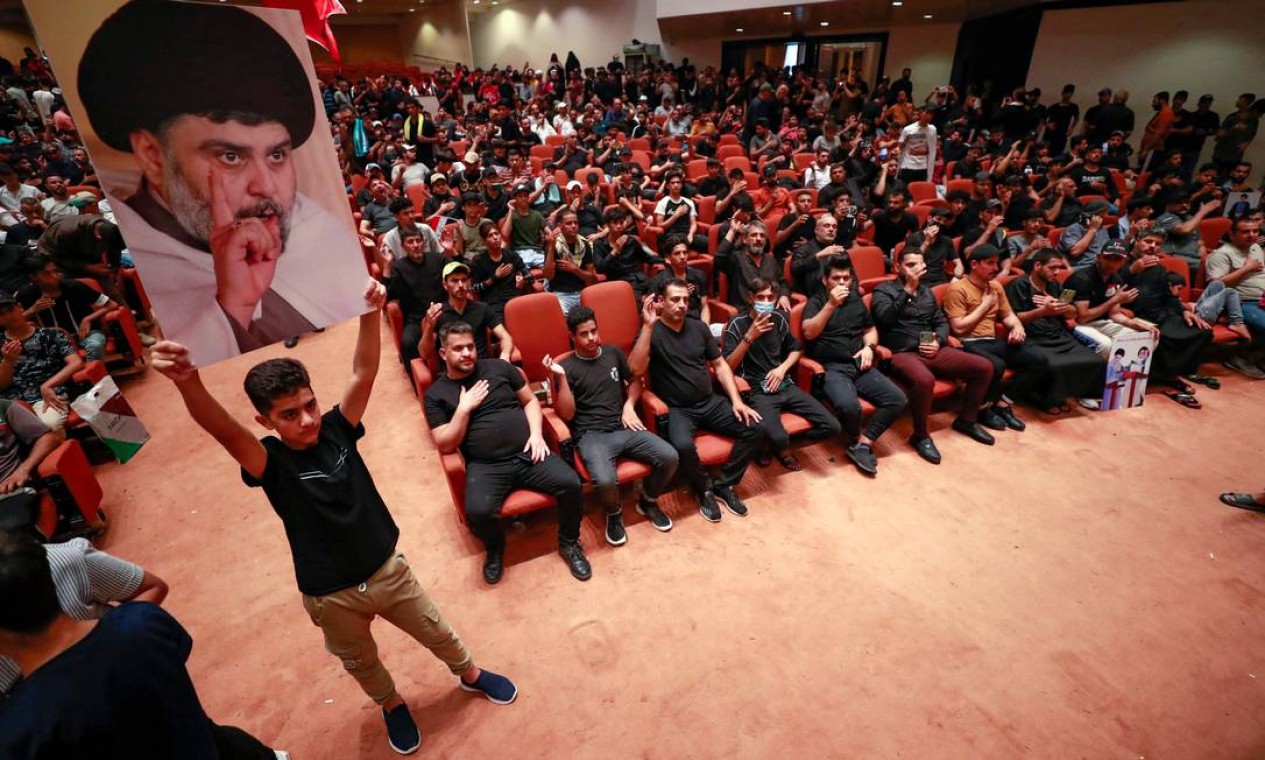Criança segura cartaz com foto do clérigo iraquiano Moqtada Sadr diante apoiadores que ocupam parlamento pelo quinto dia consecutivo, em protesto contra indicação de primeiro-ministro de oposição, mesmo tendo conquistado maior parte do Congresso Foto: AHMAD AL-RUBAYE / AFP