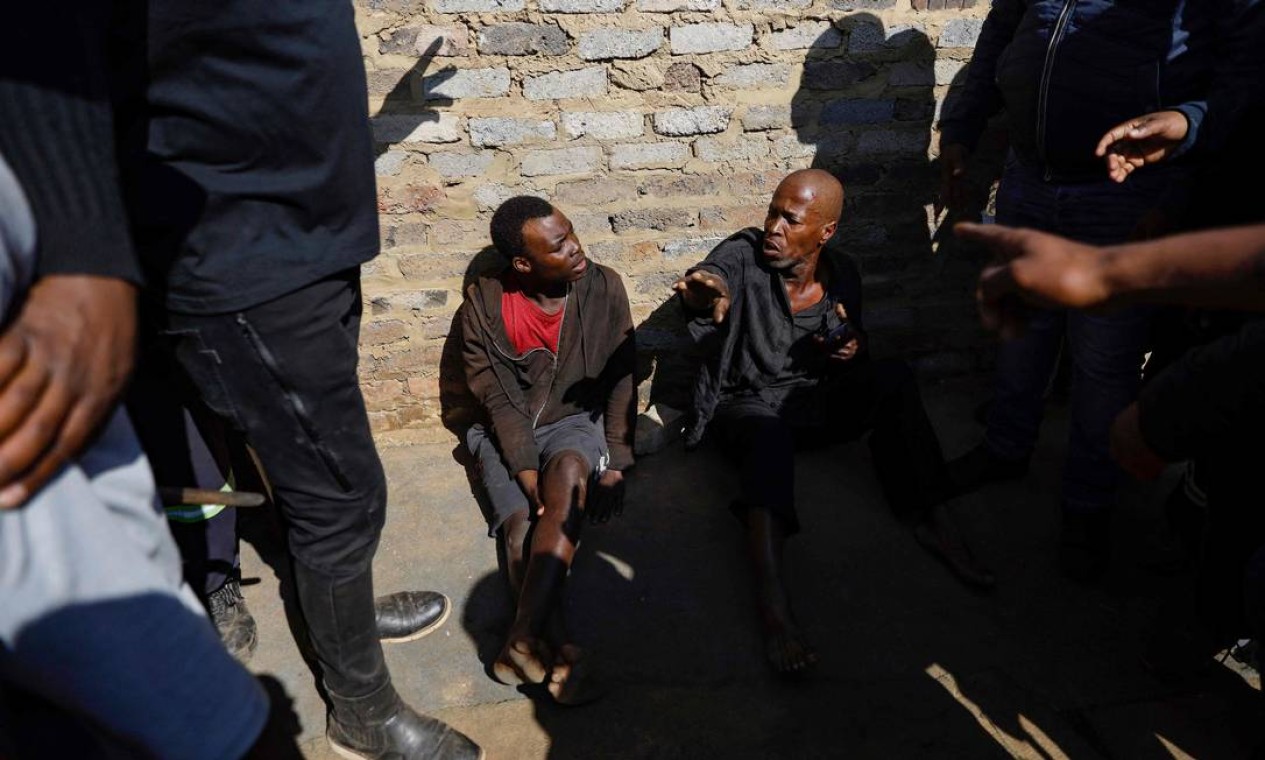Suspeitos de garimpo ilegal são encurralados por membros da comunidade enquanto protestam contra a prática e o aumento do crime na área de Kagiso, área de Joanesburgo, capital da África do Sul Foto: GUILLEM SARTORIO / AFP