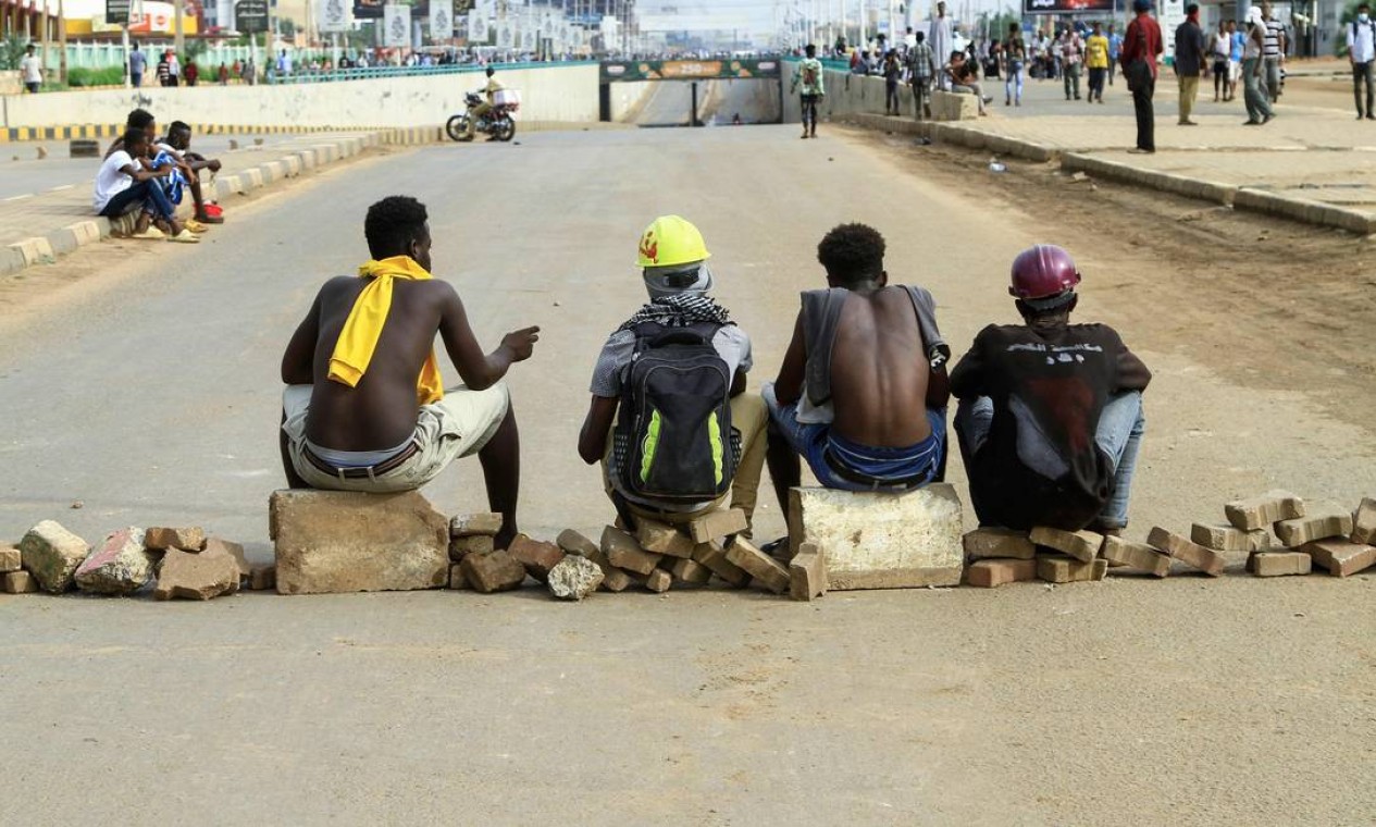 Sudaneses bloqueiam estrada no sul da capital Cartum contra o golpe militar do ano passado Foto: AFP
