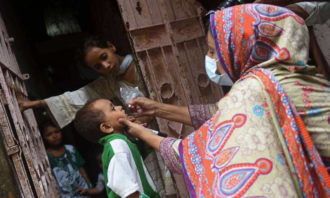 Profissional de saúde administra gotas de poliomielite a uma criança durante uma campanha de vacinação contra a poliomielite em Karachi, Paquistão Foto: RIZWAN TABASSUM / AFP