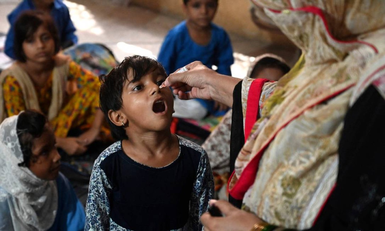 Agente de saúde administra a vacina contra a poliomielite em uma escola durante uma campanha de vacinação em Lahore, no Paquistão Foto: ARIF ALI / AFP