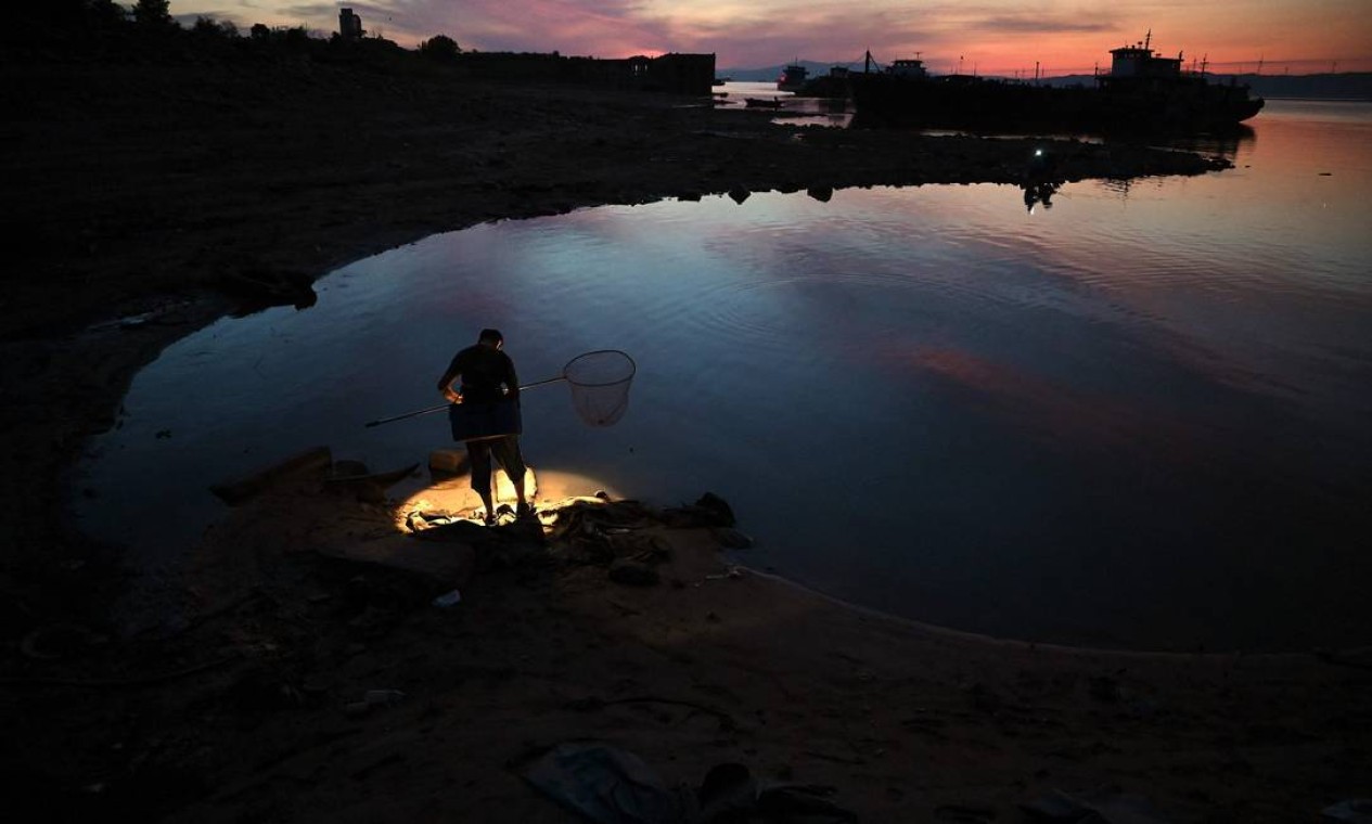 Pescador fica às margens do maior lago Poyang de água doce da China em Juijiang Foto: NOEL CELIS / AFP
