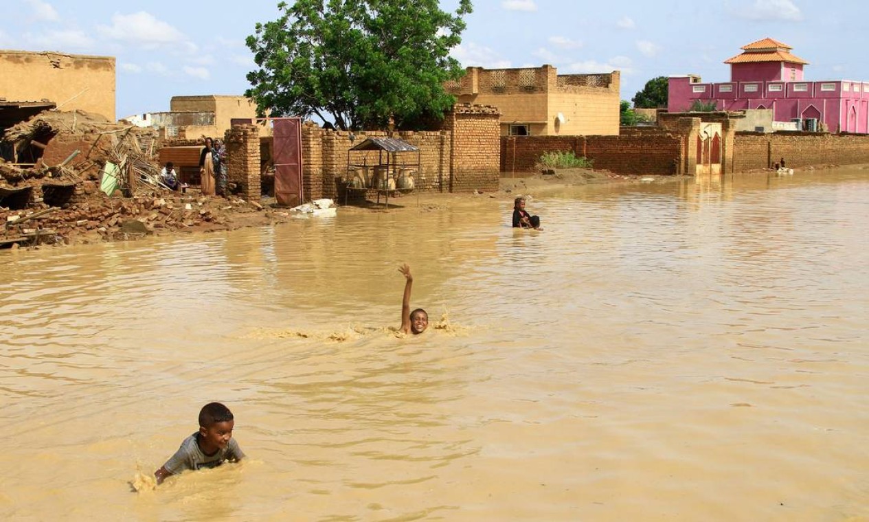 Crianças sudanesas nadam nas águas da enchente na cidade de Iboud, 250 km ao sul da capital Cartum Foto: EBRAHIM HAMID / AFP