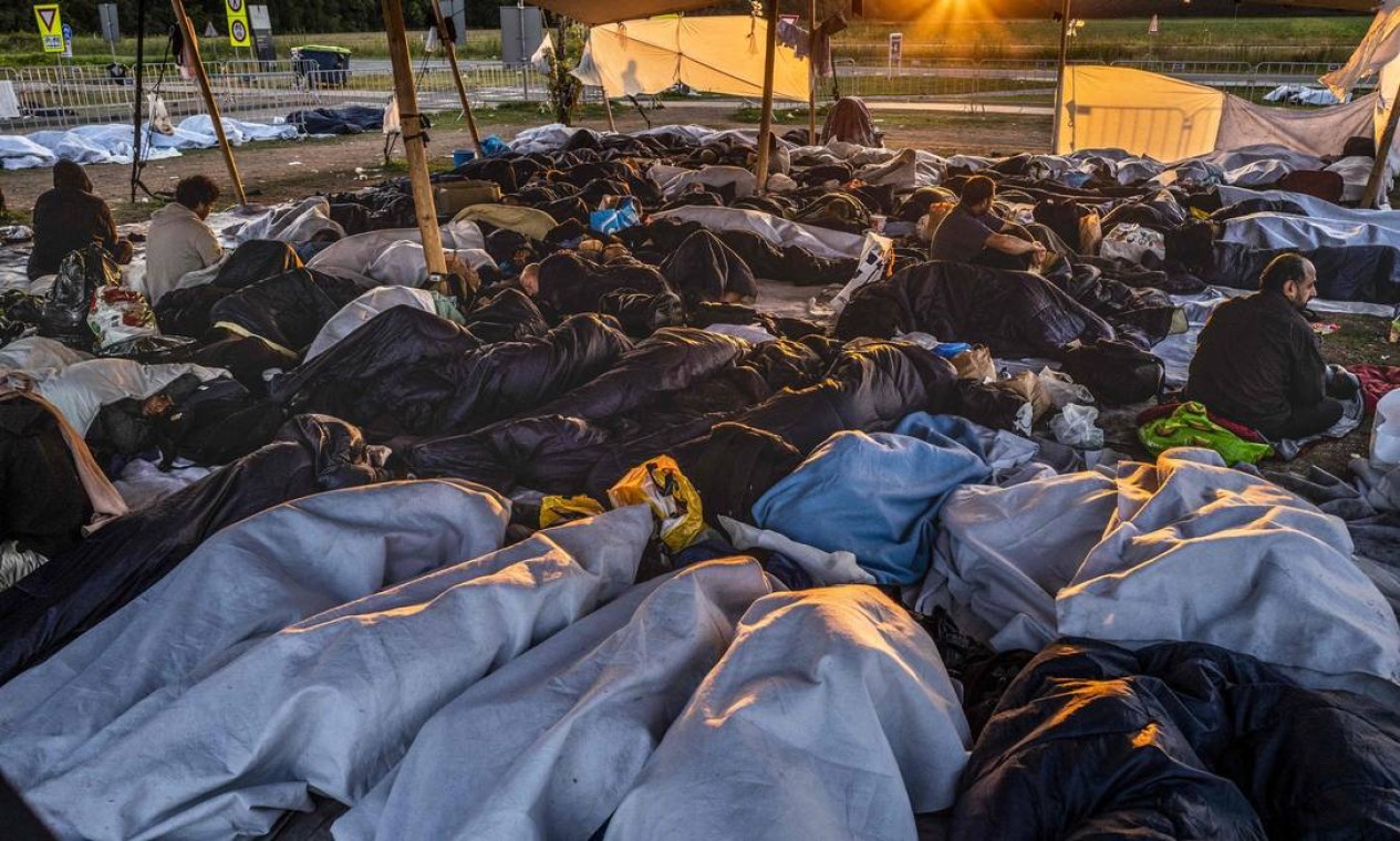 Centenas de refugiados dormem do lado de fora do portão do centro de pedidos em Ter Apel, Holanda Foto: VINCENT JANNINK / AFP