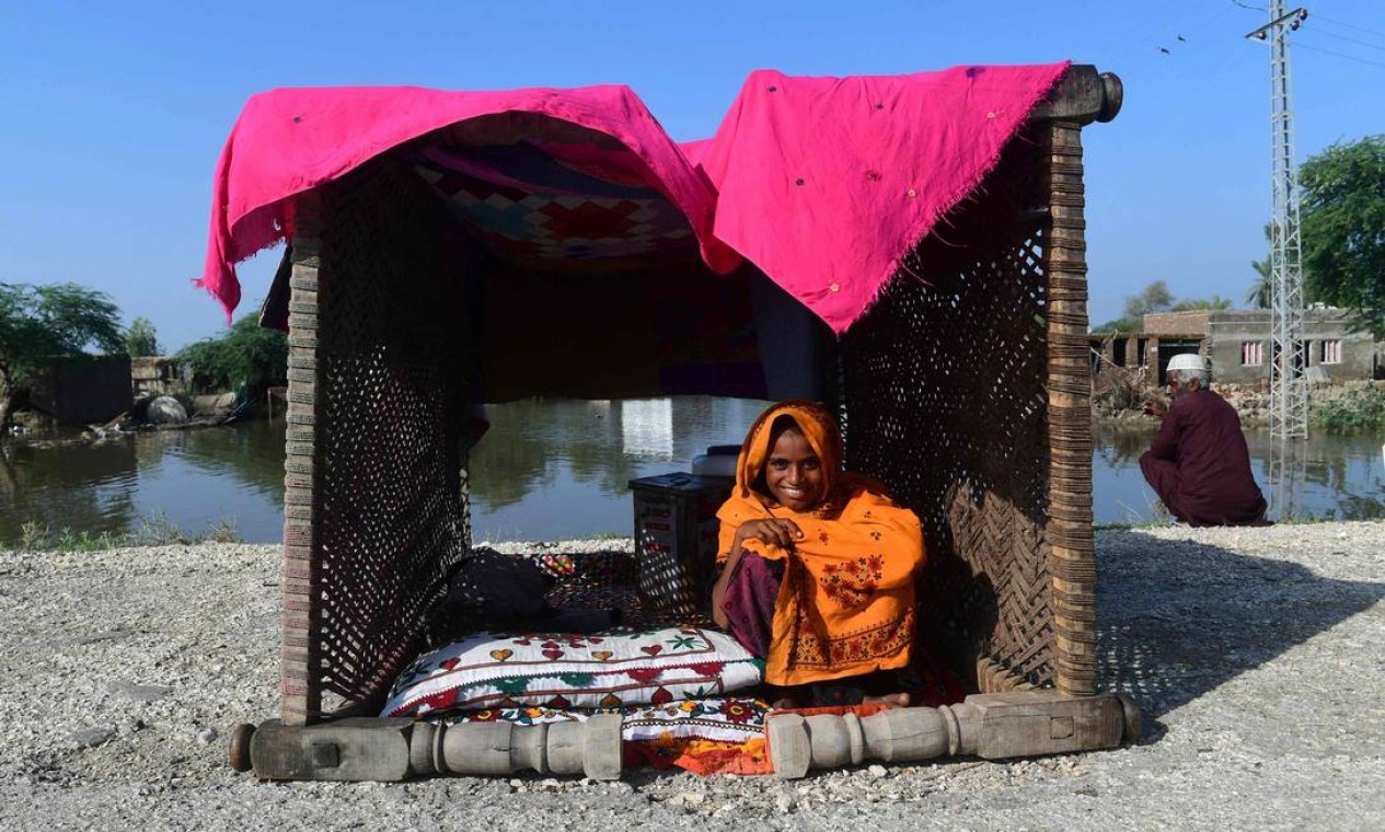 Moradora afetada por enchentes posa em sua tenda improvisada na área atingida de Shikarpur, na província de Sindh. As chuvas de monção submergiram um terço do Paquistão Foto: ASIF HASSAN / AFP