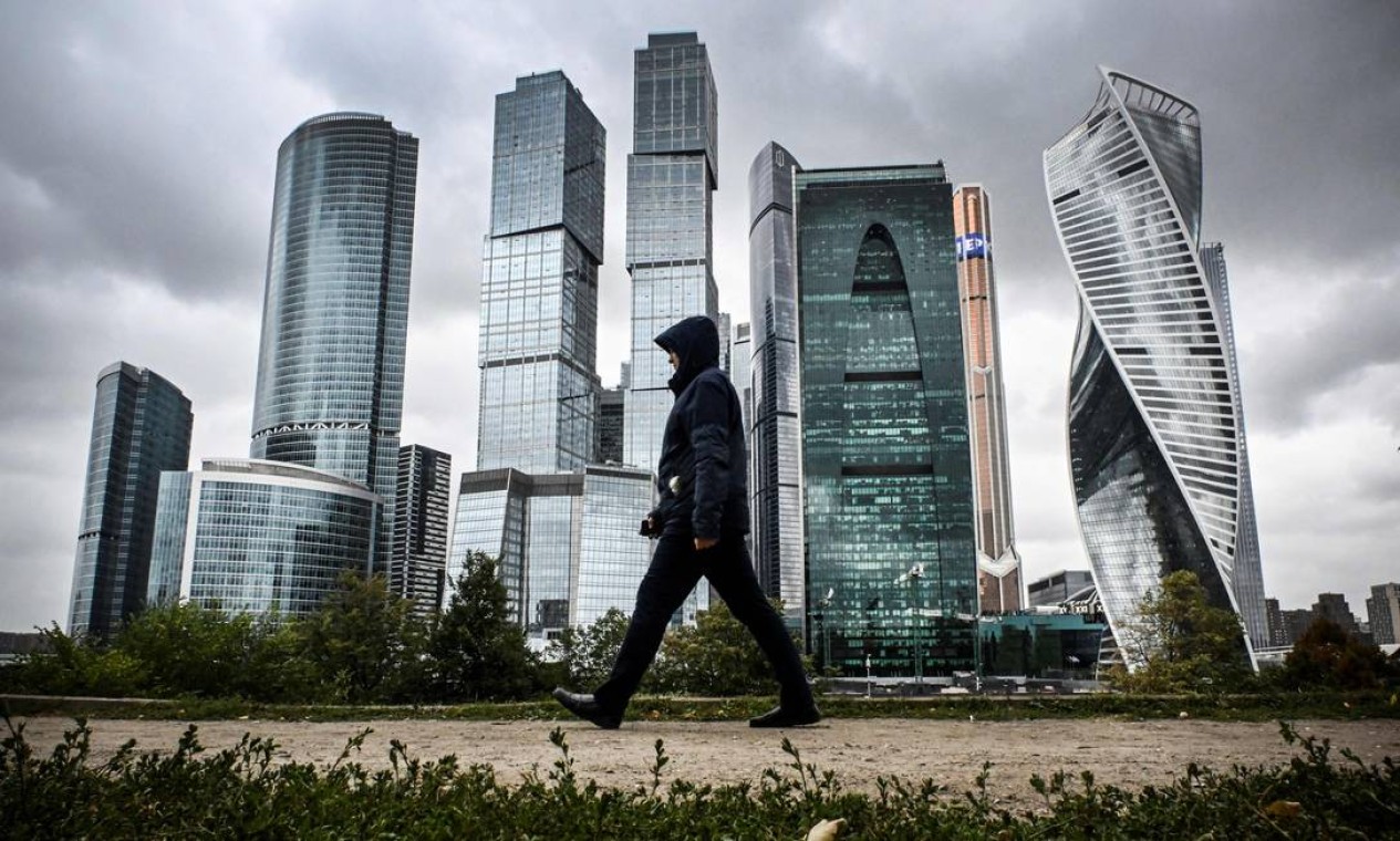 Homem passa pelos prédios do Centro Internacional de Negócios de Moscou. Foto: ALEXANDER NEMENOV / AFP