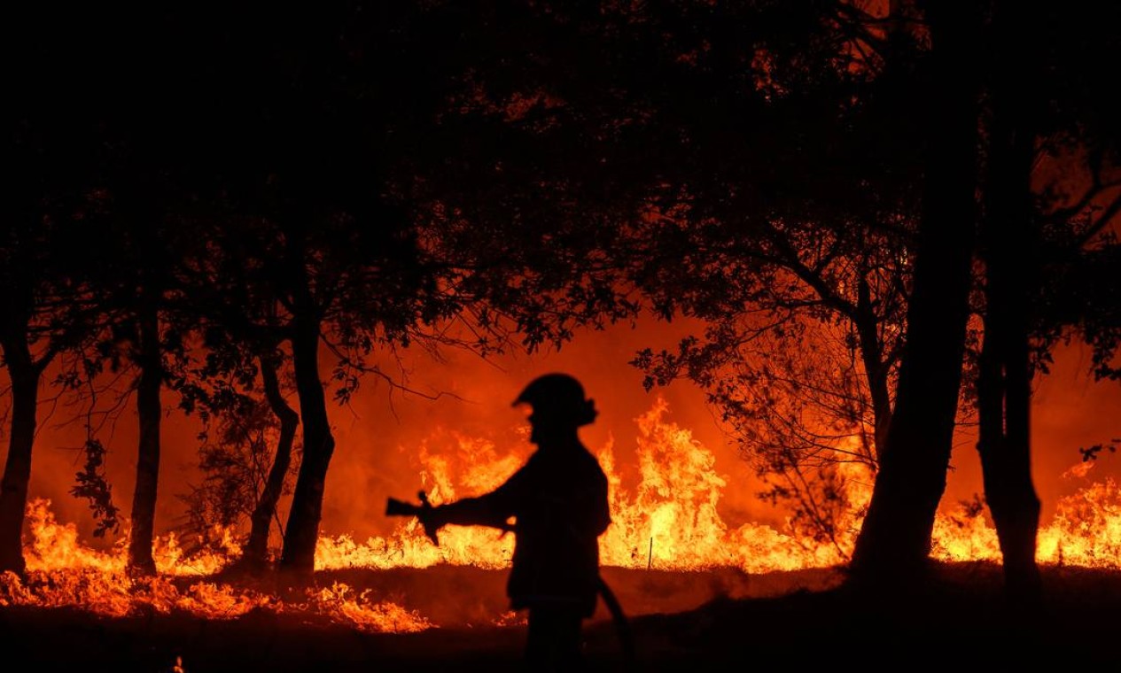 Bombeiro combate incêndio noturno em Saumos, perto de Bordeaux, sudoeste da França, onde moradores precisaram ser evacuados Foto: PHILIPPE LOPEZ / AFP