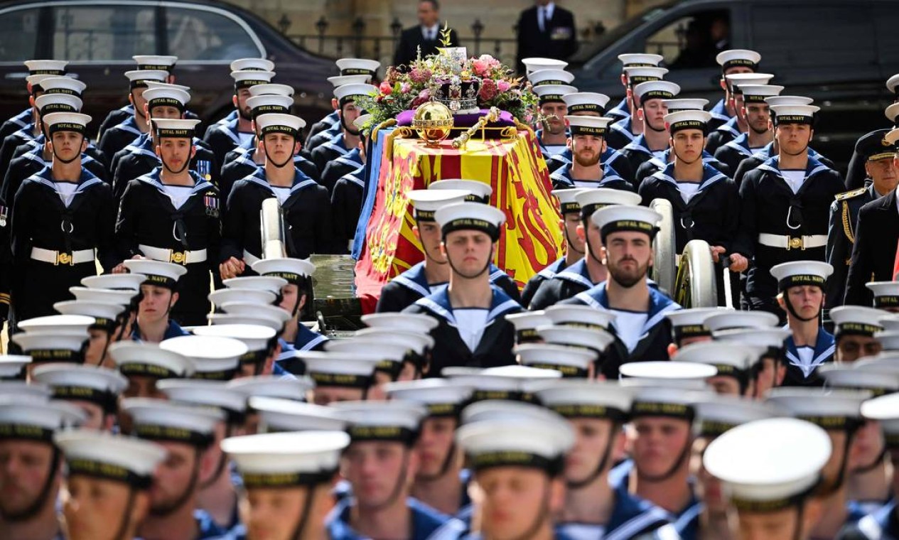 Membros da Marinha Real caminham à frente e atrás do caixão da Rainha Elizabeth II durante último adeus à monarca. Foto: MARCO BERTORELLO / AFP