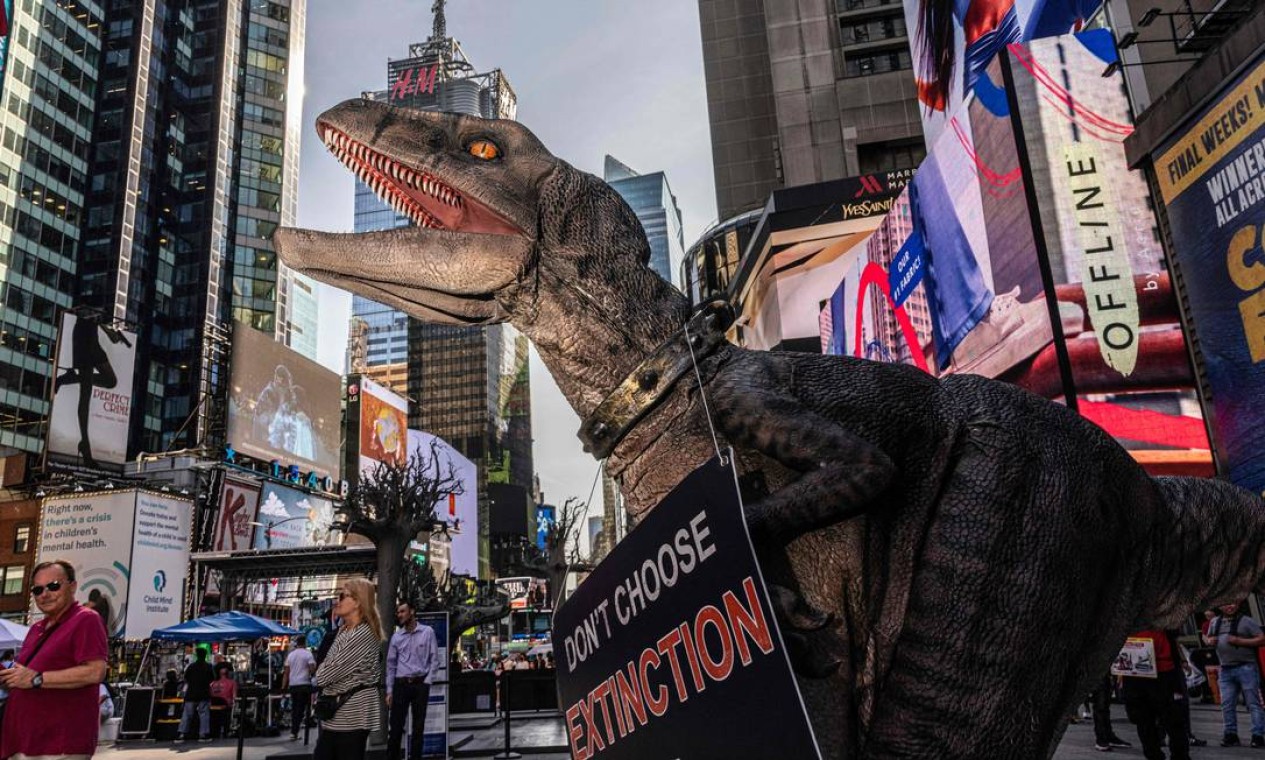 Dinossauro mascote da ONU visita a Times Square, em Nova York, para conscientizar o público sobre as mudanças climáticas. Foto: ALEX KENT / AFP