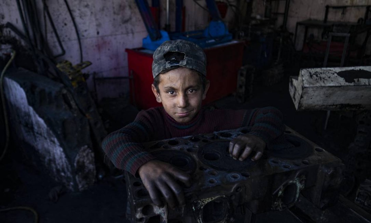 Menino trabalha em uma garagem na cidade de Raqa, no norte da Síria. Foto: DELIL SOULEIMAN / AFP