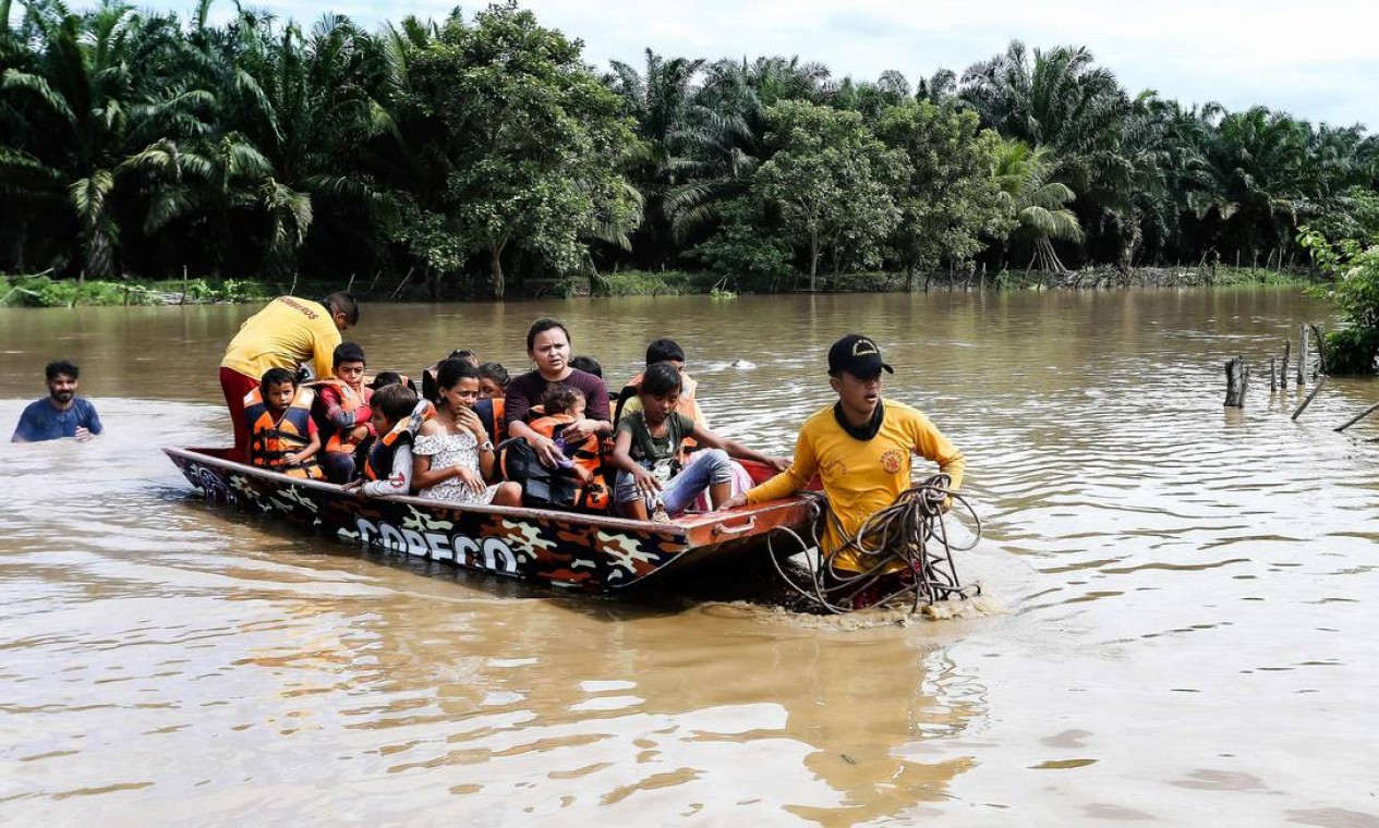 Pessoas afetadas por inundações causadas pela tempestade tropical Julia são evacuadas de barco, no município de Choloma, departamento de Cortes, Honduras Foto: WENDELL ESCOTO / AFP