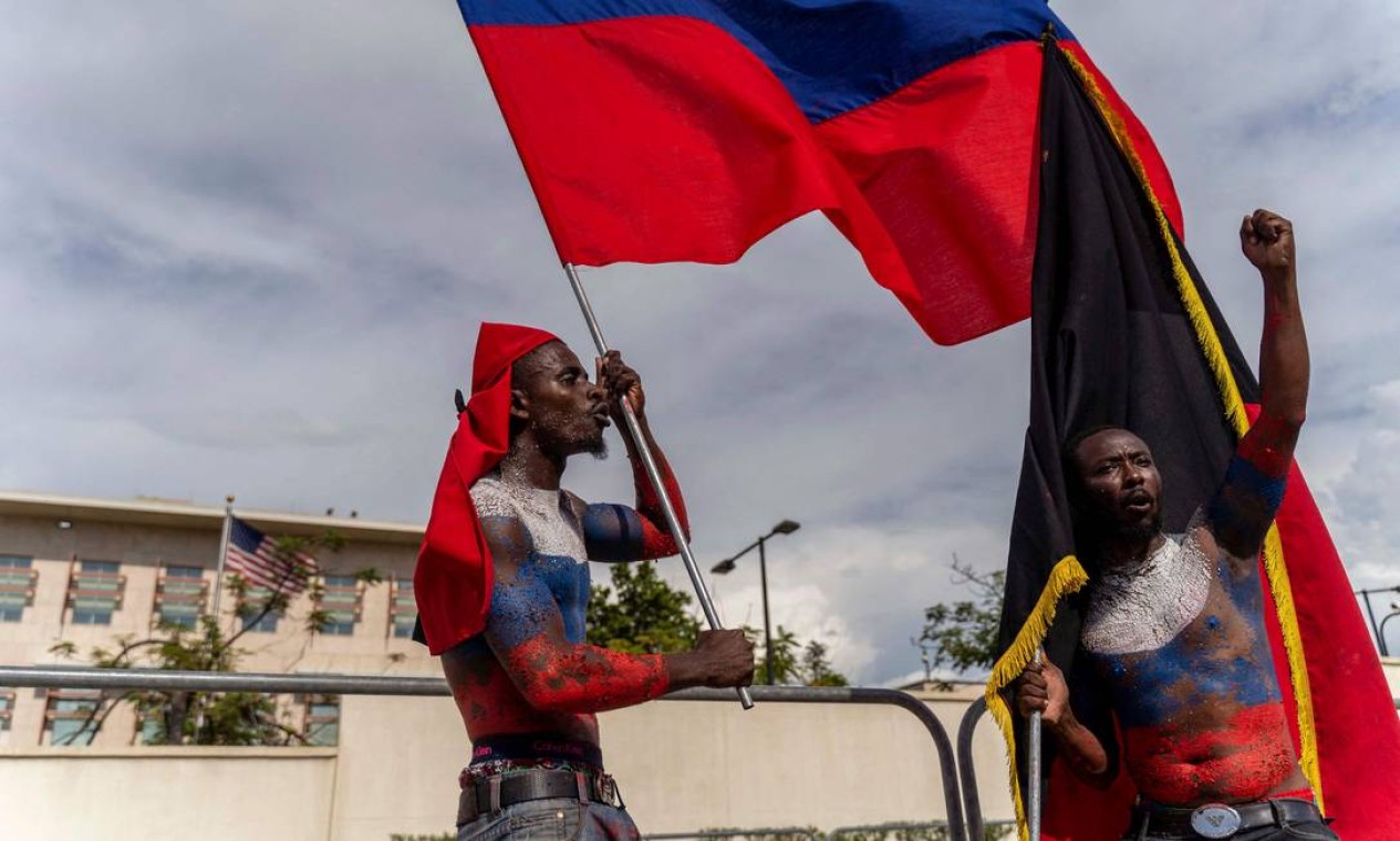 Manifestantes agitam uma bandeira russa em frente à embaixada americana durante o Dia de Jean-Jacques Dessalines – herói da independencia, em Porto Príncipe, Haiti Foto: RICHARD PIERRIN / AFP