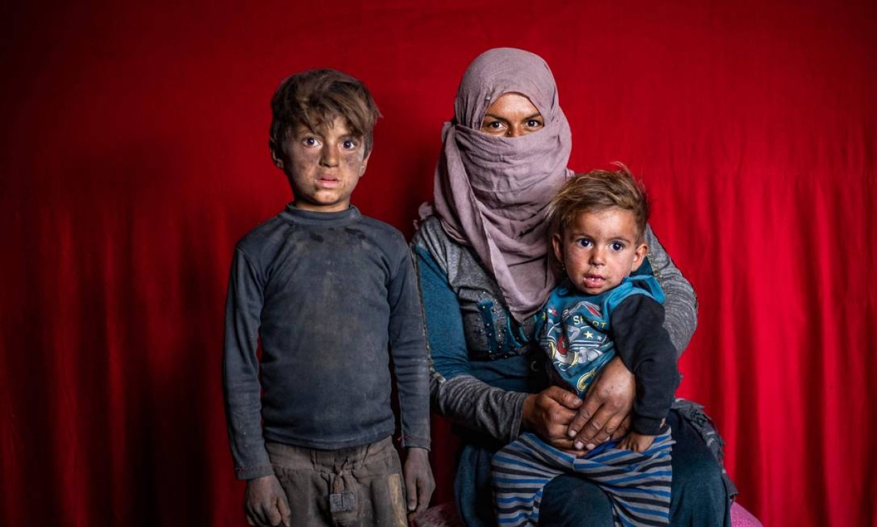 Sírios deslocados de Deir Ezzor, posam para uma foto no campo de Sahlah al-Banat, no interior de Raqa Foto: DELIL SOULEIMAN / AFP