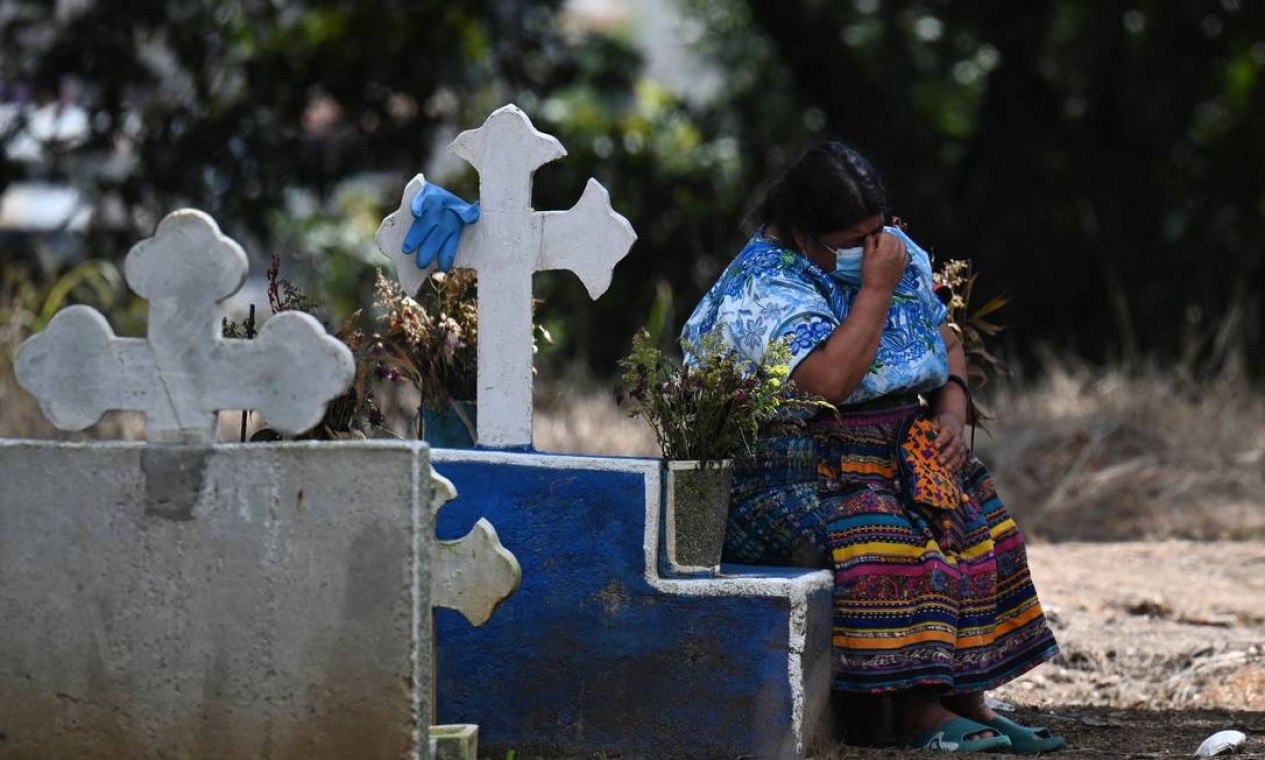 Mulher indígena chora ao lado de um túmulo na área de pessoas mortas por COVID-19 no Cemitério La Verbena, na Cidade da Guatemala Foto: JOHAN ORDONEZ / AFP
