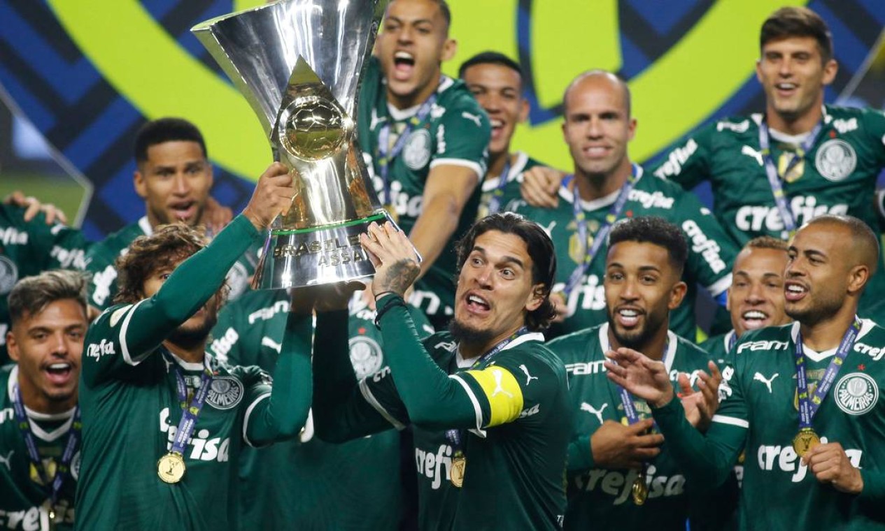Jogadores do Palmeiras comemoram com o troféu após conquistar pela 11ª vez o Campeonato Brasileiro, no estádio Allianz Park Foto: MIGUEL SCHINCARIOL / AFP