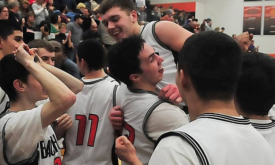 Companheiros abraçam Wes Leonard (o mais alto), que acabou morrendo pouco após fazer a cesta da vitória em jogo de basquete colegial nos EUA - Foto: AP