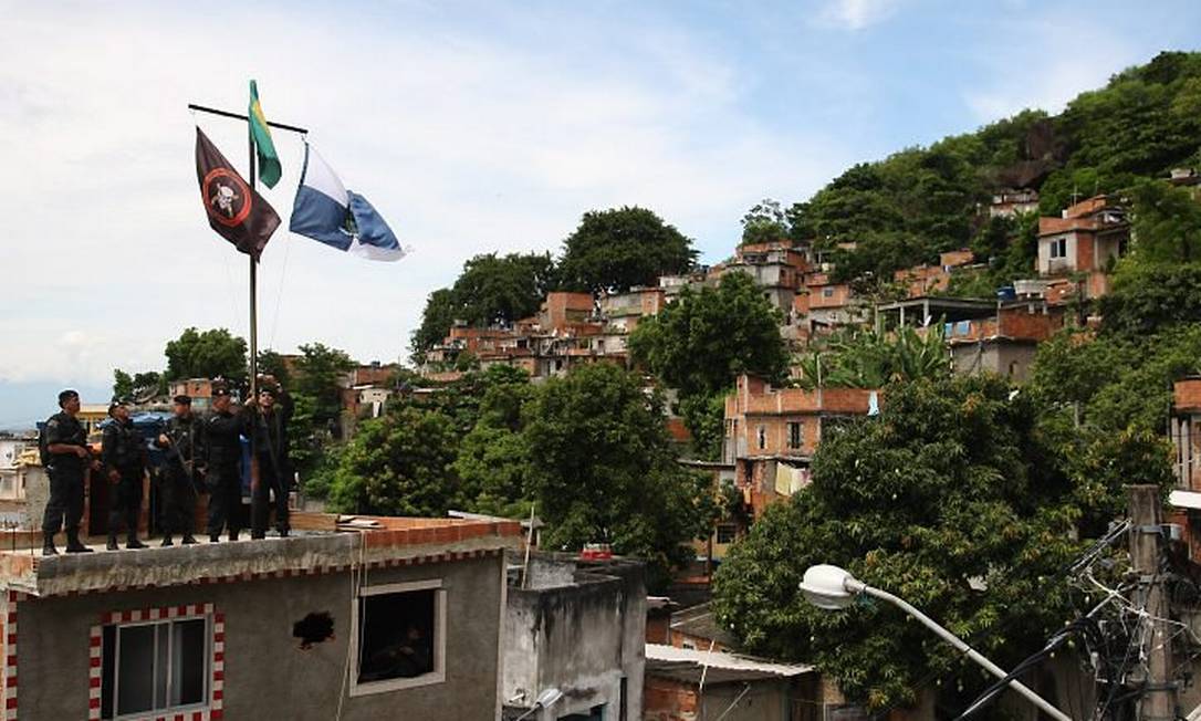 Bope ocupa o Morro de São João para implantar a UPP. Soldados do Bope hasteando a bandeira do Bope (Foto: Marco Antonio Cavalcanti Agência O Globo)