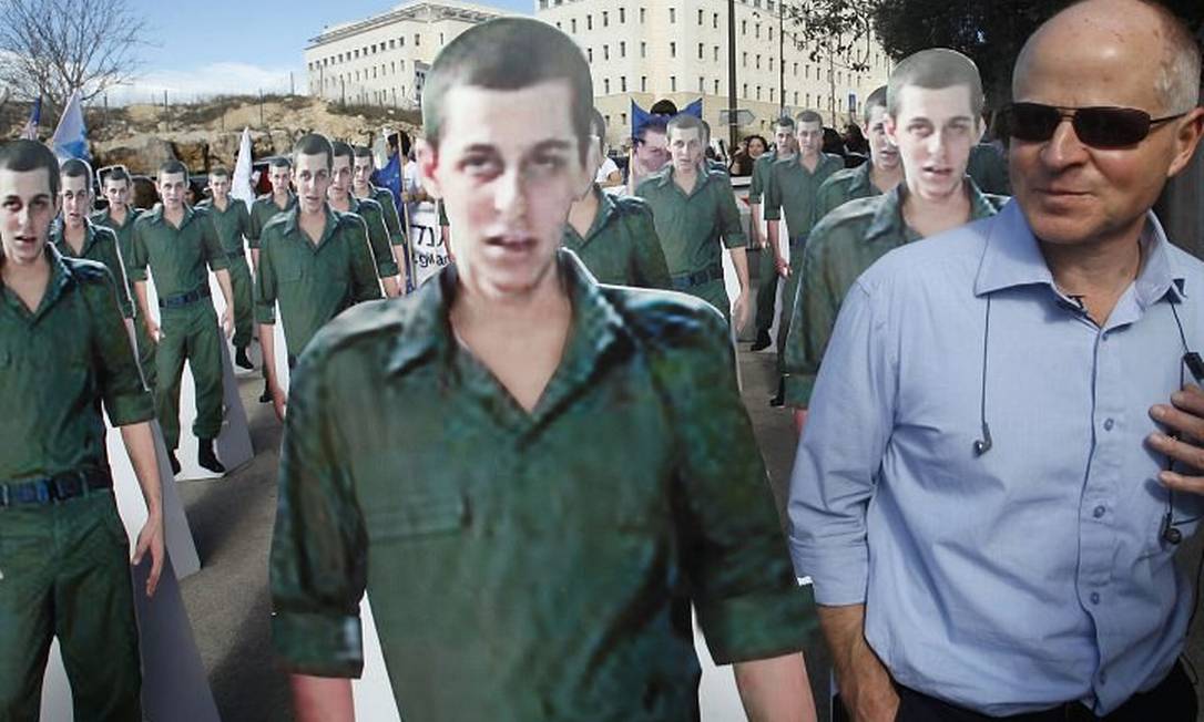 O pai de Shalit, Noam, em meio a dezenas de figuras do filho em protesto em Jerusalém Reuters