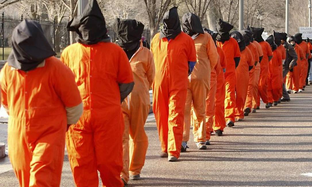 Encapuzados-e-de-uniforme-manifestantes-representam-os-prisioneiros-de-Guantanamo-num-protesto-perto-da-Casa-BrancaReuters.jpg