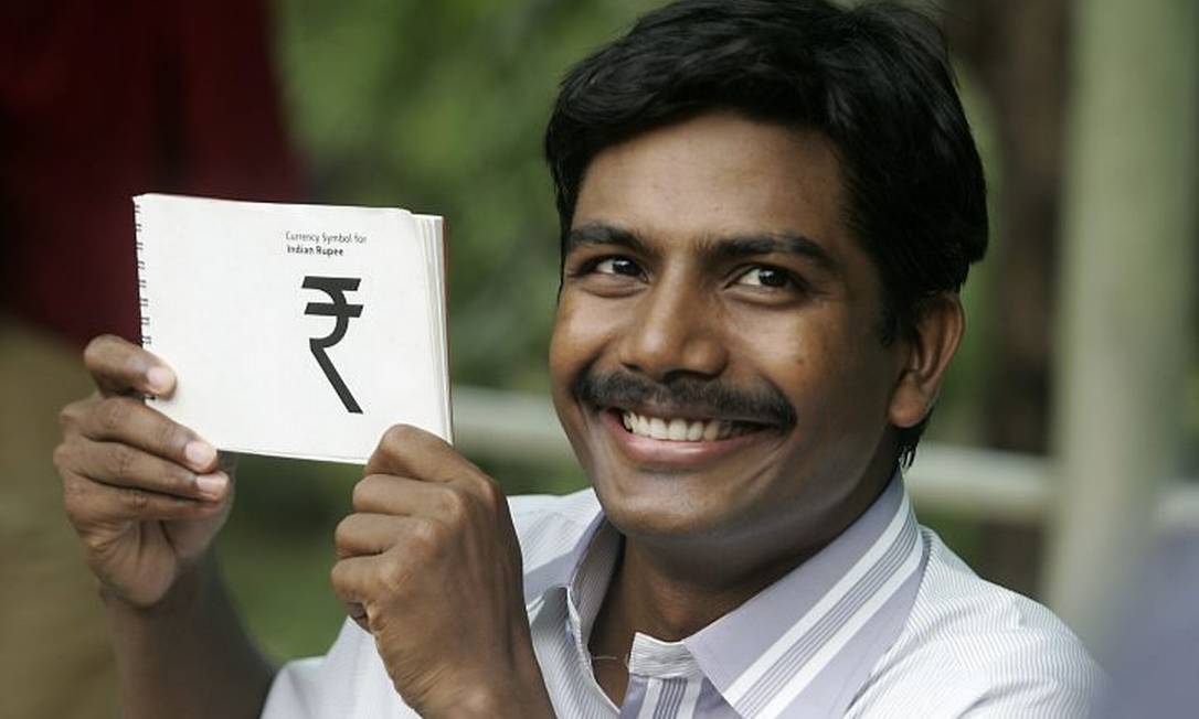 O ganhador do concurso, D.Udaya Kumar, feliz da vida com seu símbolo vencedor nas mãos AFP