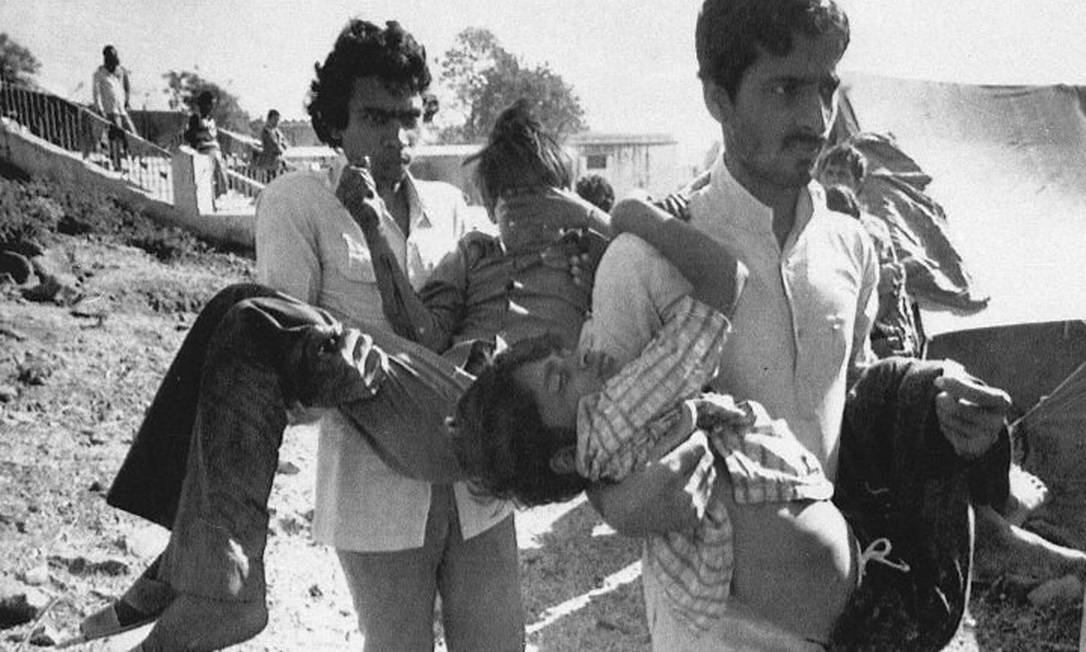 Foto de 5 de dezembro de 1984 mostra dois homens carregando crianças afetadas pelo vazamento de gás de uma fábrica da Union Carbide em Bhopal, na Índia - AP