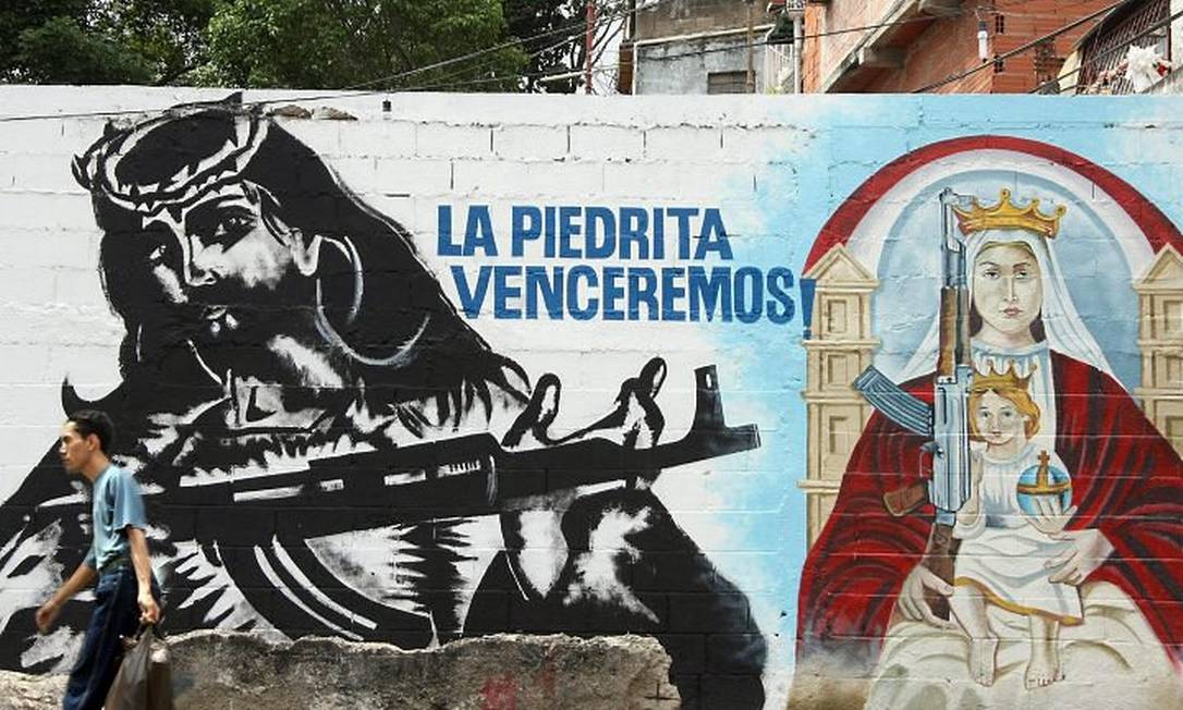 Grafite assinado pelo 'coletivo La Piedrita' no bairro 23 de Enero, em Caracas, representando Jesus Cristo e Nossa Senhora armados com fuzis - Alexandra BlancoEl Nacional