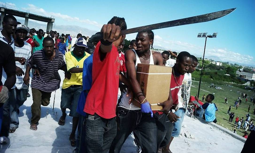 Haitianos brigam por alimentos distribuídos por um helicóptero da Marinha americana em Porto Príncipe AP