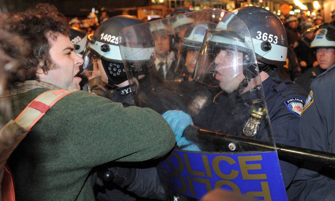 Manifestante do Ocupem Wall Street entra em confronto com policiais nas primeiras horas desta terça-feira Foto: AFP