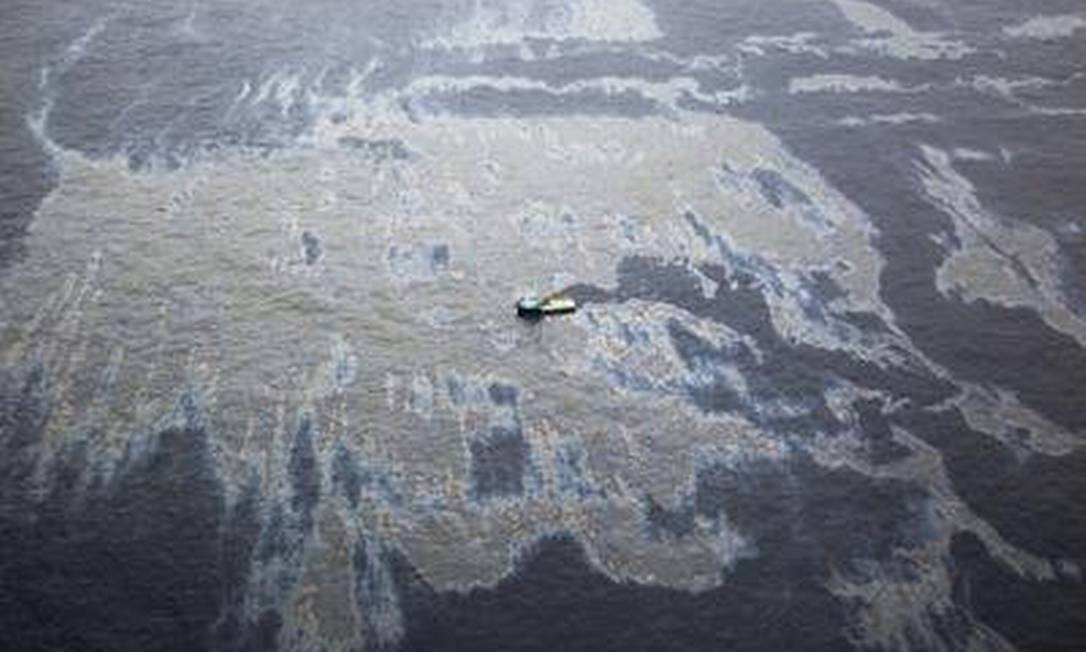 Navios trabalham para conter o óleo na área próxima a plataforma da Chevron Foto: Marcia Foletto / O Globo